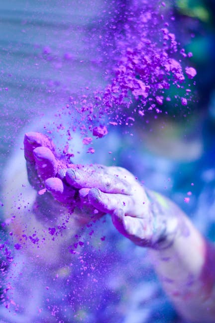 Hands throwing vibrant purple powder into the air